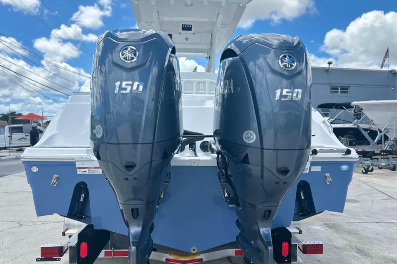 Slide: The Image of 2026 Sea Fox 268 Commander with dual Yamaha 150 outboard engines, docked under a blue sky. - 37