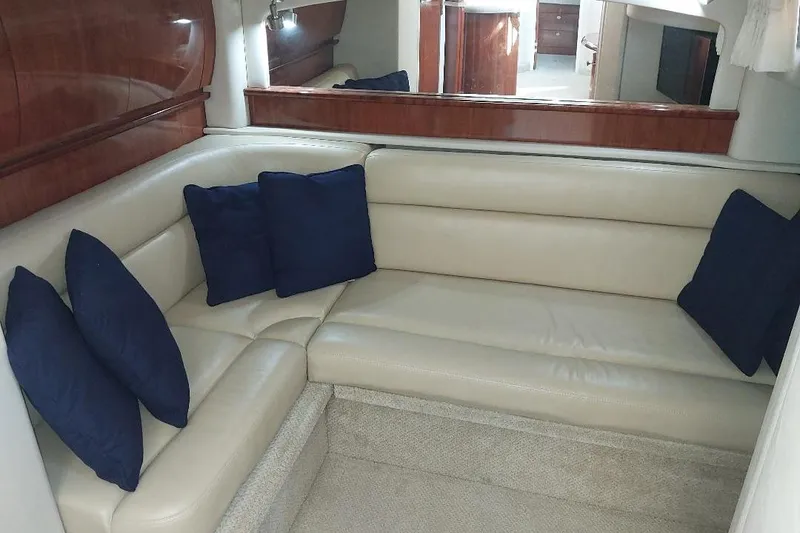 Slide: The Image of Luxurious interior of 2004 Sea Ray 420 Sundancer with beige leather seating and blue cushions. - 18