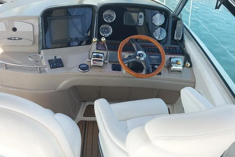 Slide: The Image of 2004 Sea Ray 420 Sundancer helm with wooden steering wheel and modern controls. - 5