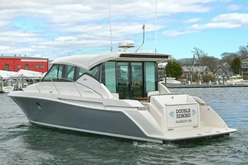 The Image of 2018 Tiara Yachts C39 Coupe docked in a serene marina under a blue sky. - 0