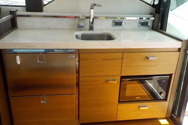 Slide: The Image of Interior of 2018 Tiara Yachts 39 Coupe with white seating and wooden table. - 10