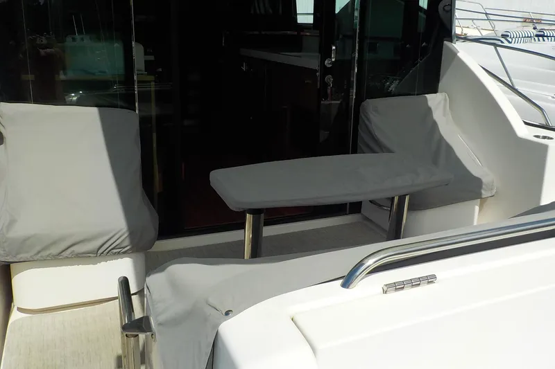 Slide: The Image of 2018 Tiara Yachts 39 Coupe interior with cushioned seating and wooden table. - 42