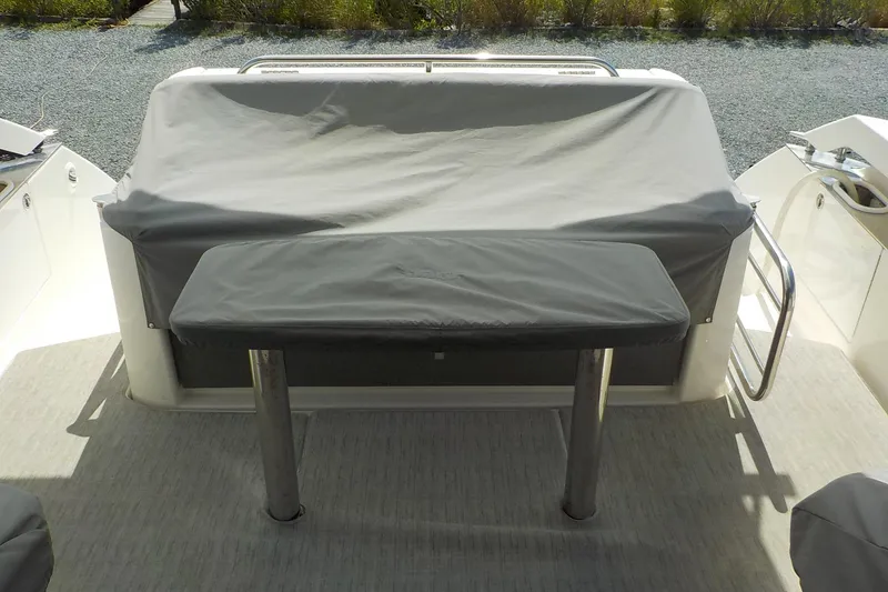 Slide: The Image of 2018 Tiara Yachts 39 Coupe interior with seating and table, docked beside another boat. - 43