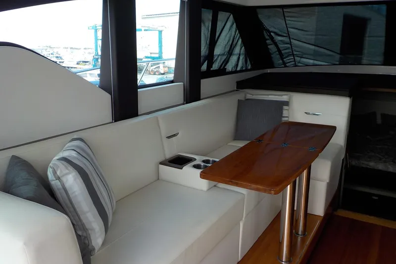 Slide: The Image of Interior of 2018 Tiara Yachts 39 Coupe, featuring modern seating and kitchenette. - 8