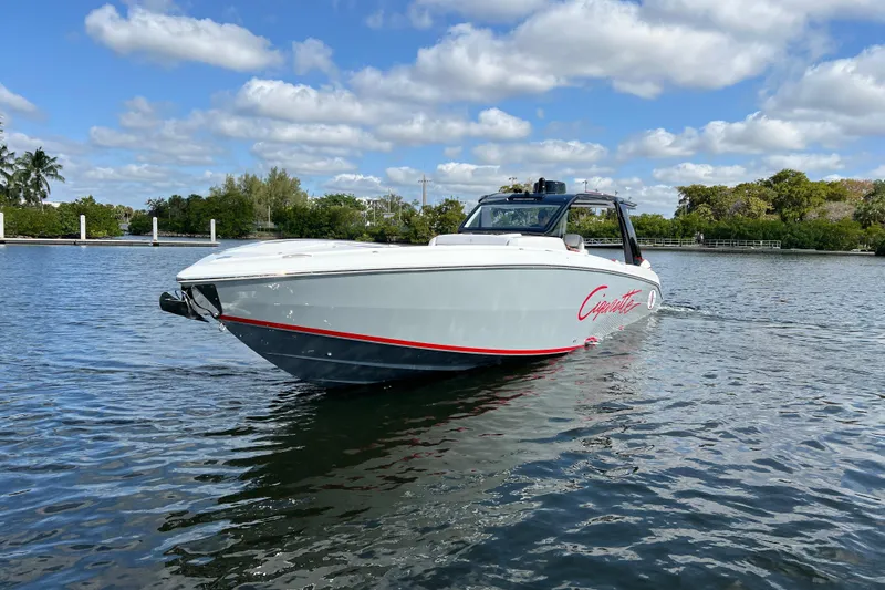 Slide: The Image of 2025 Cigarette 41 Nighthawk boat on calm water under a partly cloudy sky. - 14
