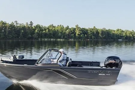 Slide: The Image of 2026 Crestliner 1650 Kodiac WT boat cruising on a serene lake with forested shoreline. - 1