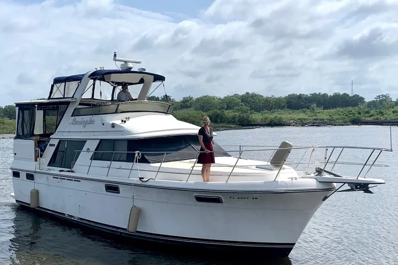 Slide: The Image of 1986 Carver 42 Aft Cabin Motoryacht on water, person standing on deck. - 0