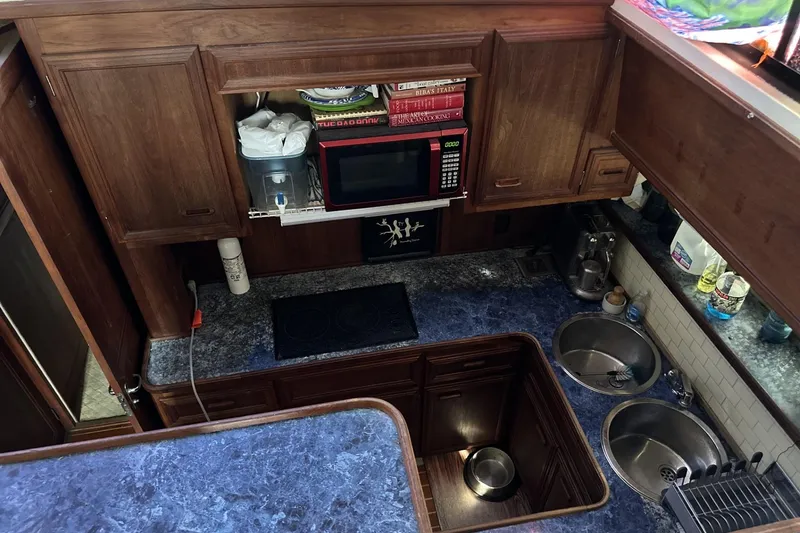 Slide: The Image of 1986 Carver 42 Aft Cabin Motoryacht kitchen with microwave, stove, and dual sinks. - 12