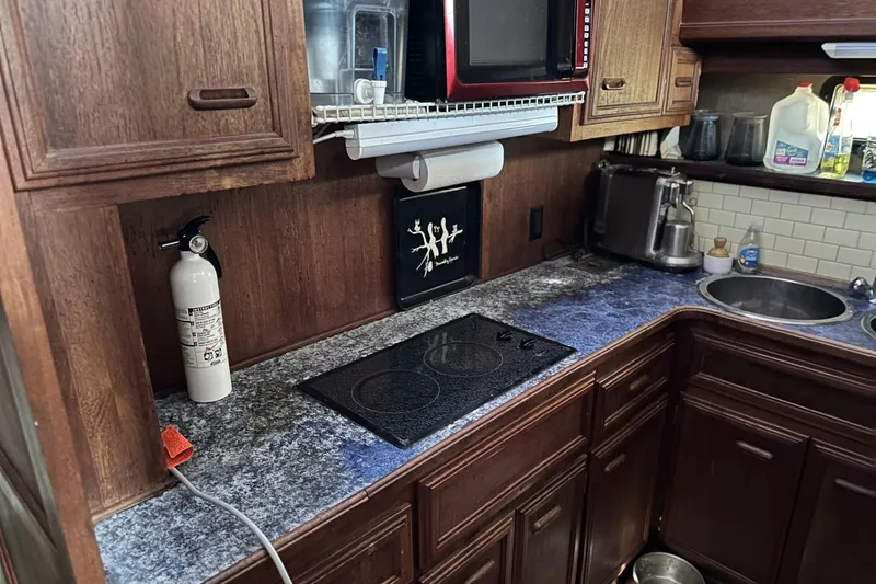 Slide: The Image of 1986 Carver 42 Aft Cabin Motoryacht kitchen with stove, microwave, and sink. - 13