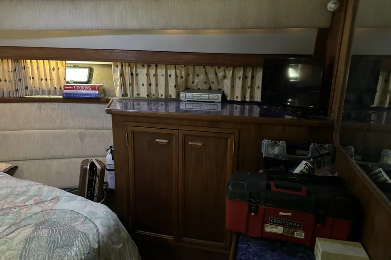 Slide: The Image of 1986 Carver 42 Aft Cabin Motoryacht interior with wooden cabinetry, books, and a Craftsman toolbox. - 18