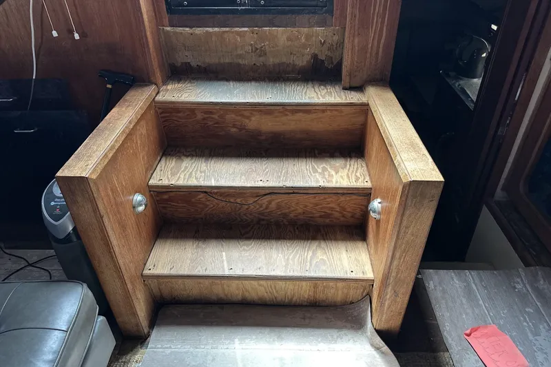 Slide: The Image of Wooden stairs inside 1986 Carver 42 Aft Cabin Motoryacht, showing wear and vintage design. - 28