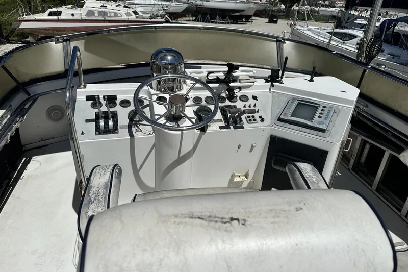 Slide: The Image of 1986 Carver 42 Aft Cabin Motoryacht helm with steering wheel and navigation controls. - 35