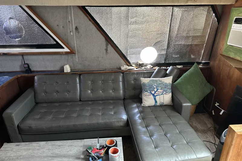 Slide: The Image of Interior of 1986 Carver 42 Aft Cabin Motoryacht with gray leather sofa and decorative pillows. - 9