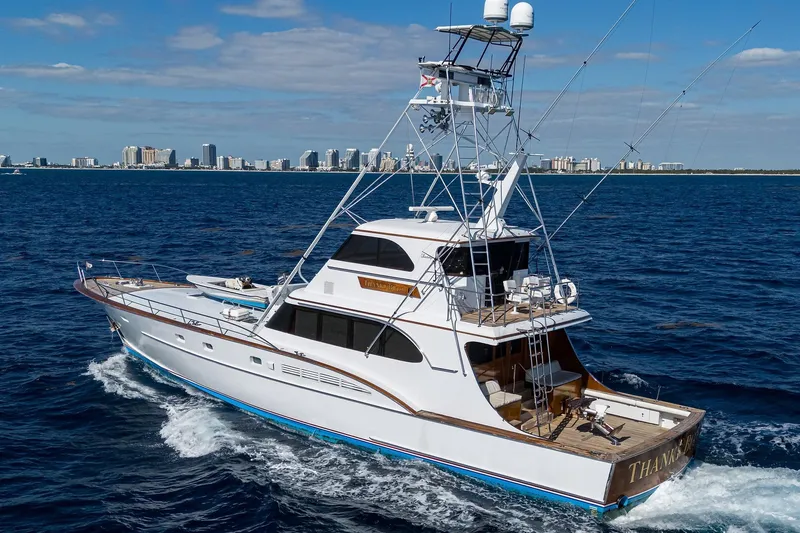 Slide: The Image of 1985 Feadship Yacht Fisherman cruising on the ocean with city skyline in background. - 11
