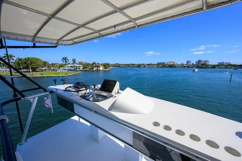 Slide: The Image of 1985 Feadship Yacht Fisherman helm with scenic waterfront view, clear skies, and palm trees. - 117