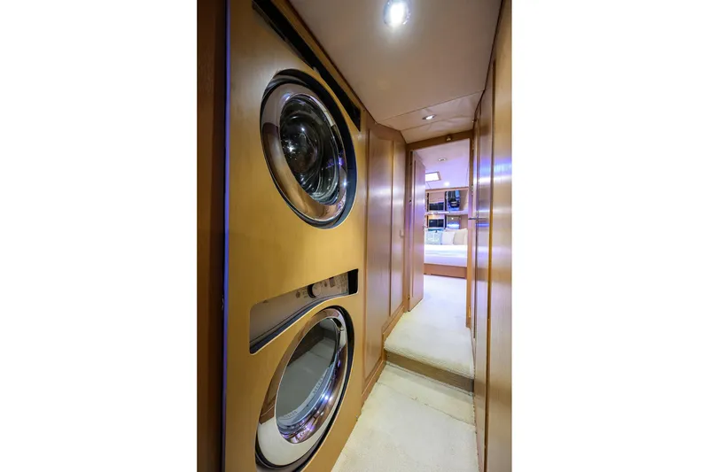 Slide: The Image of Laundry area inside 1985 Feadship Yacht Fisherman, featuring stacked washer and dryer. - 124