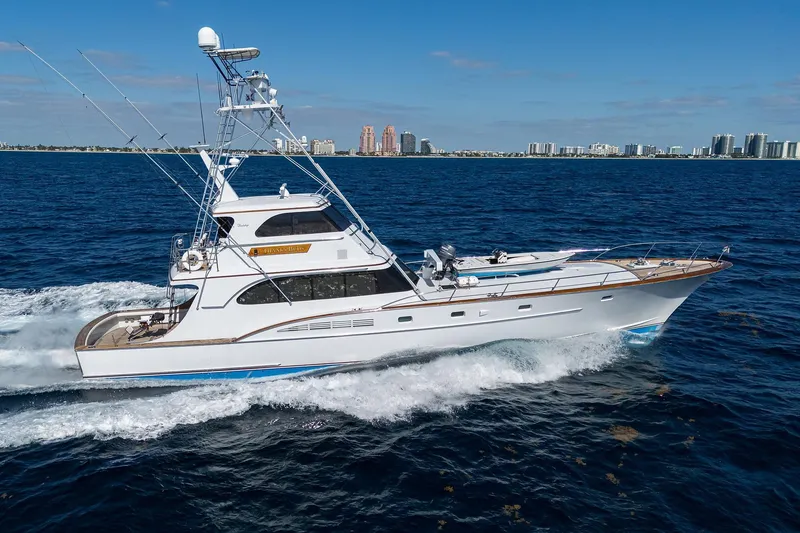 Slide: The Image of 1985 Feadship Yacht Fisherman cruising on open water, city skyline in background. - 14