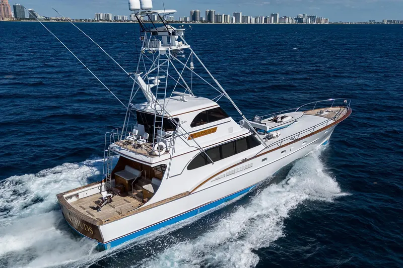 Slide: The Image of 1985 Feadship Yacht Fisherman cruising on open sea with city skyline in background. - 145