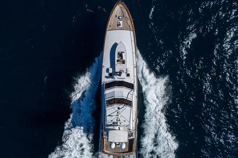 Slide: The Image of Aerial view of 1985 Feadship Yacht Fisherman cruising through deep blue ocean waters. - 147