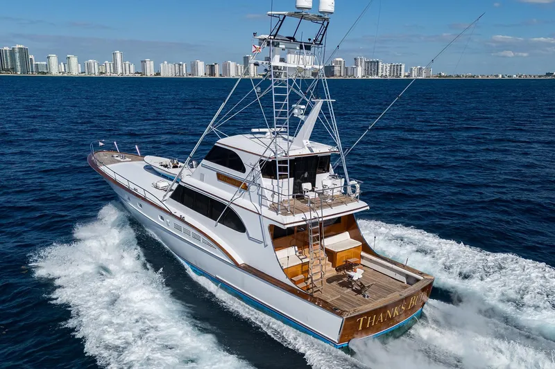 Slide: The Image of 1985 Feadship Yacht Fisherman cruising near a city skyline on a sunny day. - 148