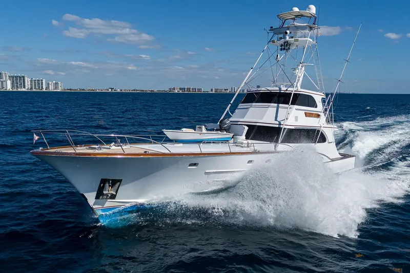Slide: The Image of 1985 Feadship Yacht Fisherman cruising on open sea with city skyline in background. - 151
