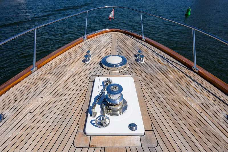 Slide: The Image of Bow of 1985 Feadship Yacht Fisherman with teak deck and winch, on calm water. - 19