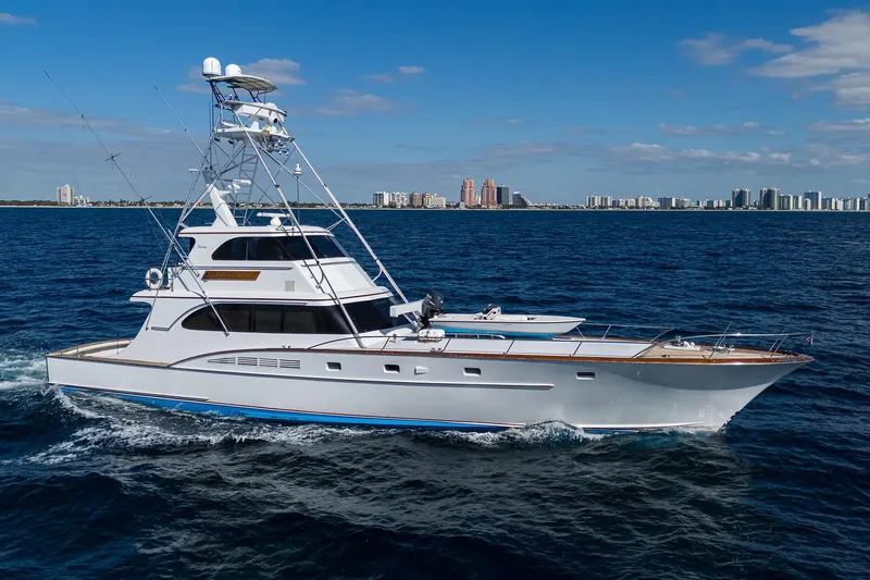 Slide: The Image of 1985 Feadship Yacht Fisherman cruising on open water with city skyline in background. - 2