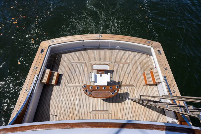 Slide: The Image of 1985 Feadship Yacht Fisherman deck with wooden flooring and fishing chair, overlooking water. - 21