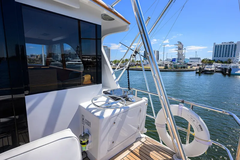 Slide: The Image of 1985 Feadship Yacht Fisherman docked, featuring helm and marina view. - 51