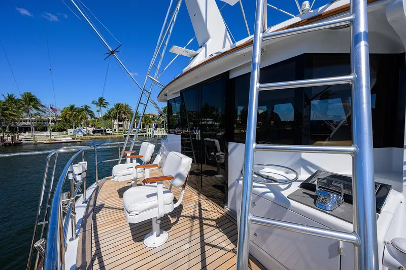 Slide: The Image of Luxurious 1985 Feadship Yacht Fisherman with deck chairs and ladder, docked by palm trees. - 53