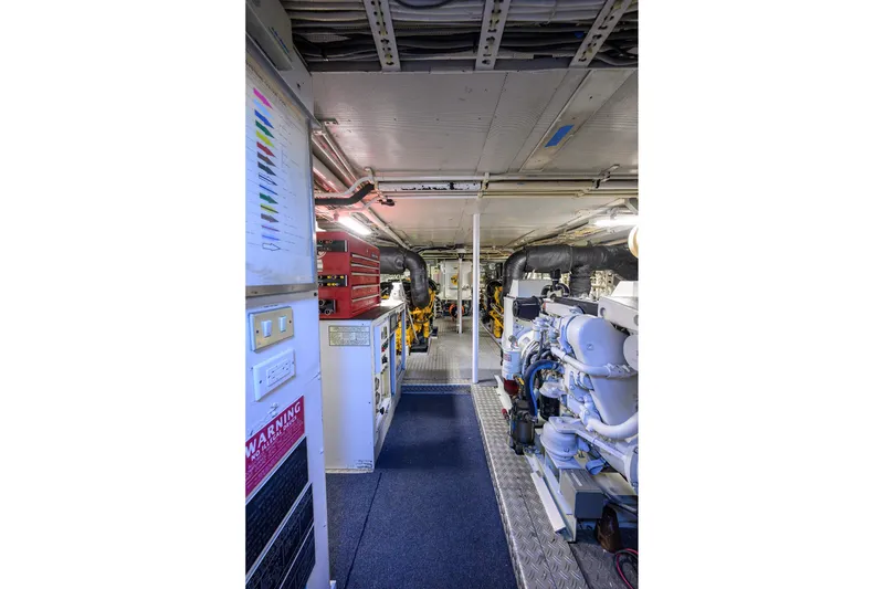 Slide: The Image of Engine room of 1985 Feadship Yacht Fisherman, featuring machinery and control panels. - 56
