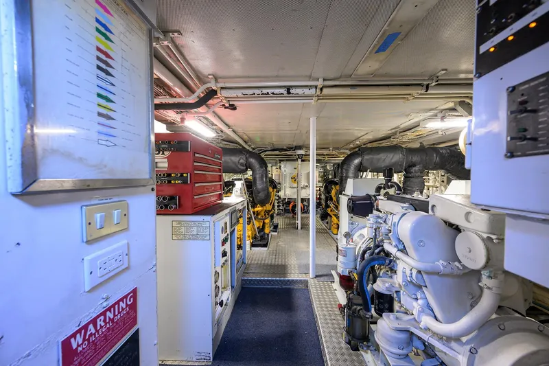 Slide: The Image of Engine room of 1985 Feadship Yacht Fisherman, featuring machinery and control panels. - 57