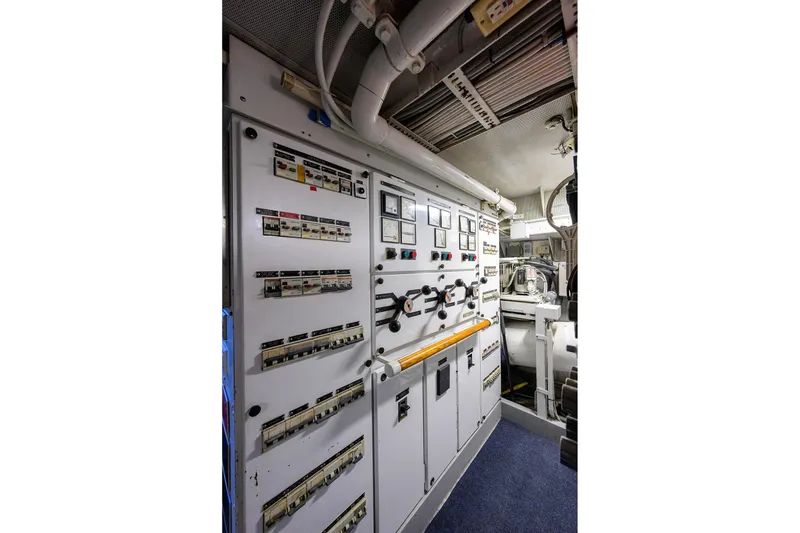 Slide: The Image of Control panel inside 1985 Feadship Yacht Fisherman, showcasing intricate electrical systems and gauges. - 63