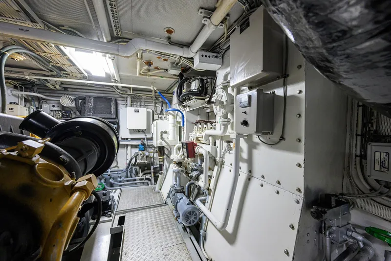 Slide: The Image of Engine room of 1985 Feadship Yacht Fisherman, showcasing complex machinery and piping systems. - 68