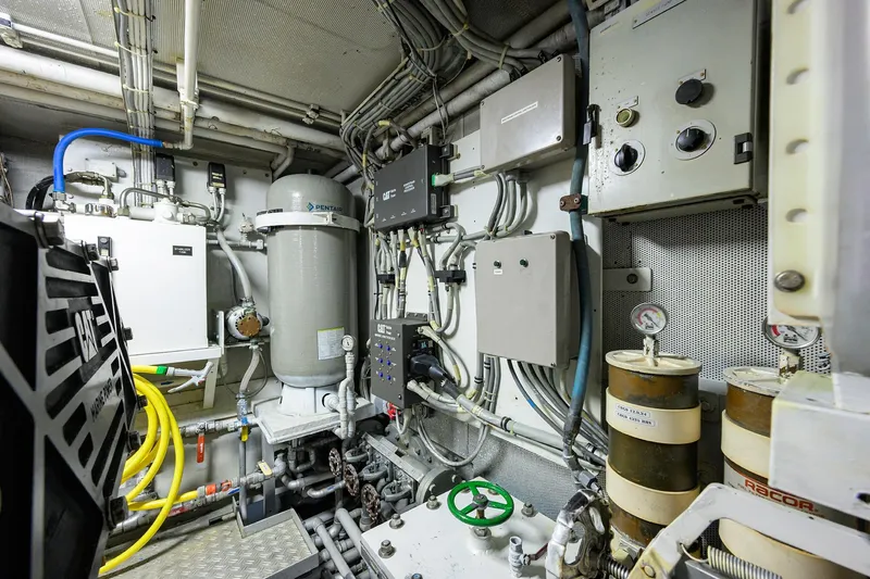 Slide: The Image of Engine room of 1985 Feadship Yacht Fisherman, featuring complex machinery and control panels. - 71