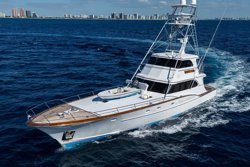 Slide: The Image of 1985 Feadship Yacht Fisherman cruising on open sea with city skyline in background. - 8