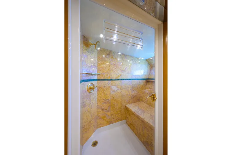 Slide: The Image of Luxurious marble shower interior on 1985 Feadship Yacht Fisherman, featuring gold fixtures and seating. - 85