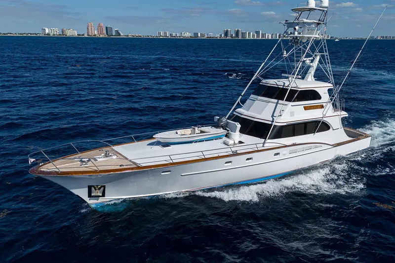 Slide: The Image of 1985 Feadship Yacht Fisherman cruising on open sea with city skyline in background. - 9