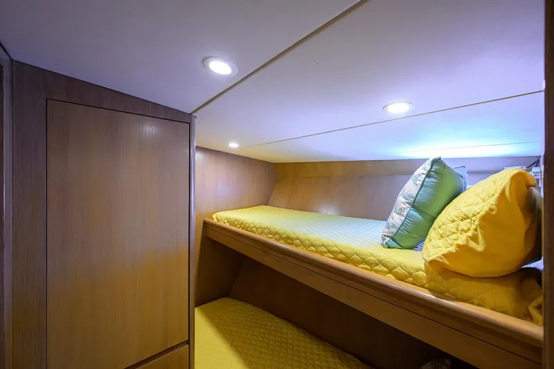 Slide: The Image of Cozy cabin with bunk beds on 1985 Feadship Yacht Fisherman, featuring yellow bedding and wood paneling. - 92
