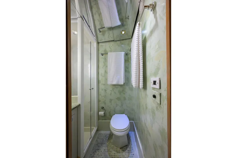 Slide: The Image of Compact bathroom on 1985 Feadship Yacht Fisherman with modern fixtures and green walls. - 94