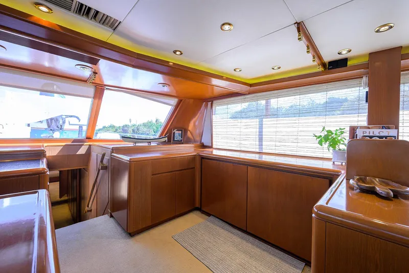 Slide: The Image of Luxurious 1985 Feadship Yacht Fisherman interior with wooden cabinetry and large windows. - 98