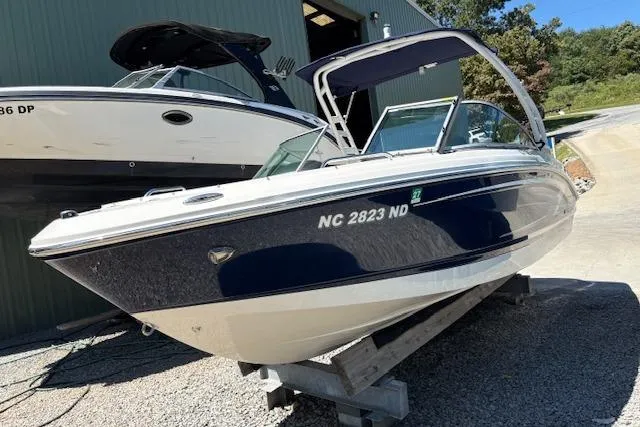 Slide: The Image of 2023 Chaparral 21 SSi boat on display, parked outdoors on a sunny day. - 2