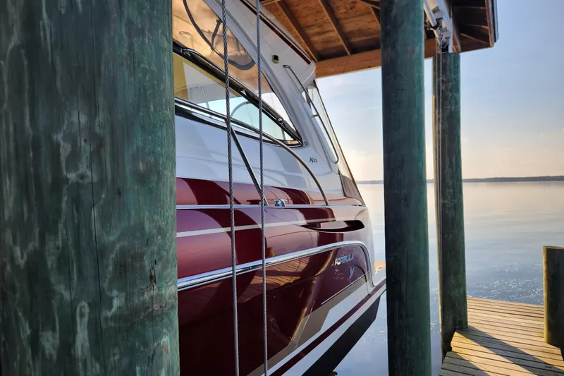Slide: The Image of 2015 Formula 34 Performance Cruiser docked by wooden posts on a serene lake. - 20