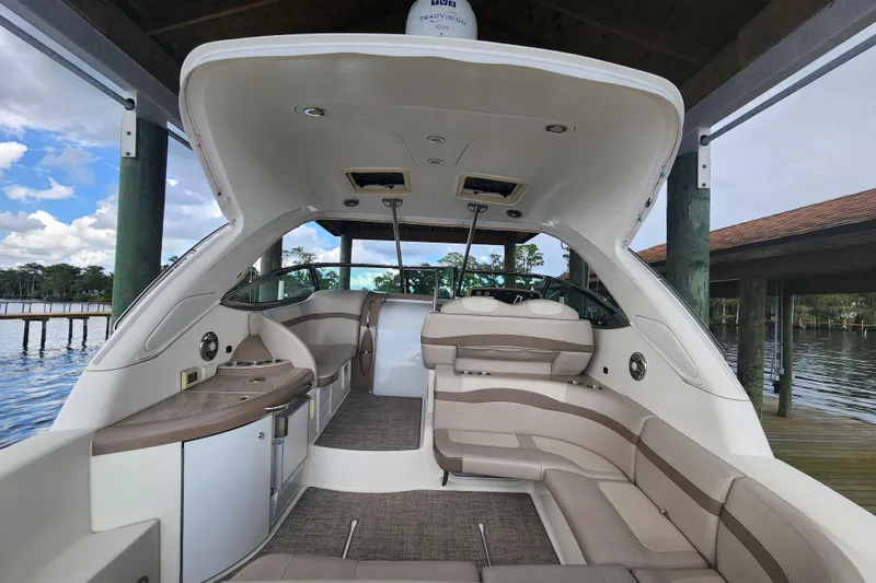 Slide: The Image of 2015 Formula 34 Performance Cruiser interior with seating and cabinetry, docked by a scenic waterfront. - 31