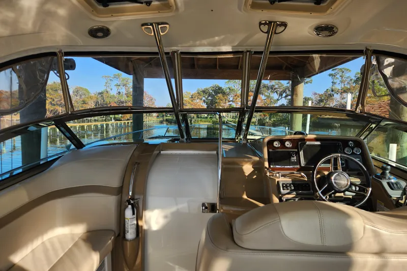 Slide: The Image of 2015 Formula 34 Performance Cruiser interior with steering wheel and dashboard, docked by scenic waterway. - 33