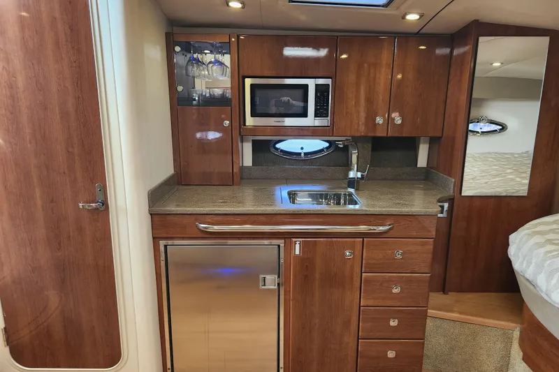 Slide: The Image of 2015 Formula 34 Performance Cruiser interior with kitchenette, featuring wood cabinetry and modern appliances. - 71