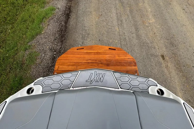 Slide: The Image of 2022 MasterCraft NXT20 boat with teak swim platform and gray deck, viewed from above. - 20