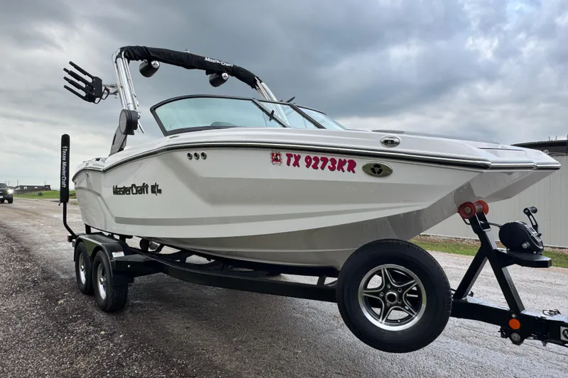 Slide: The Image of 2022 MasterCraft NXT20 boat on trailer, overcast sky, side view. - 3