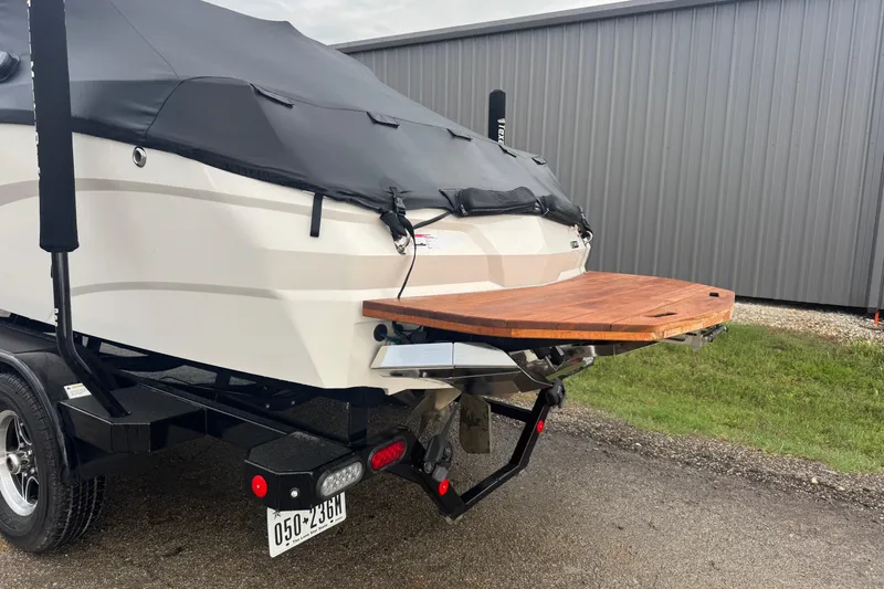 Slide: The Image of 2022 MasterCraft NXT20 boat with cover on trailer, featuring wooden swim platform. - 7