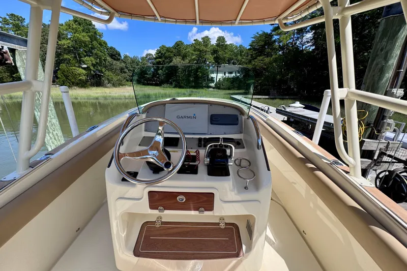 Slide: The Image of 2015 Chris-Craft Catalina 26 helm with Garmin navigation, docked by a scenic waterway. - 5